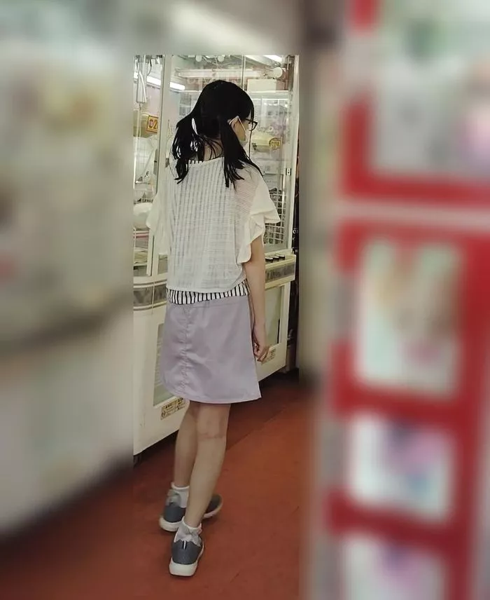 A slender girl absorbed in a game, carefully photographed in polka dot pants.